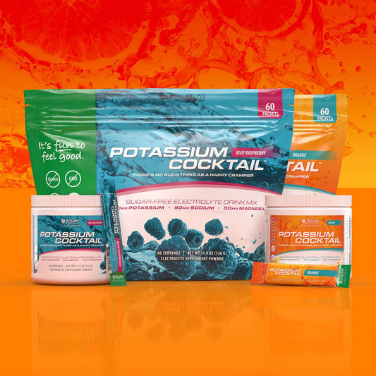 Jigsaw Potassium Cocktail sugar-free electrolyte powder packets and tubs in blue raspberry and orange flavors on orange background